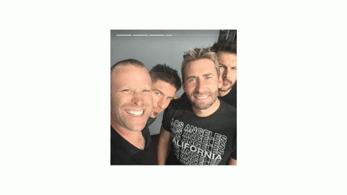 three men smile brightly with the camera flash shining through their eyes