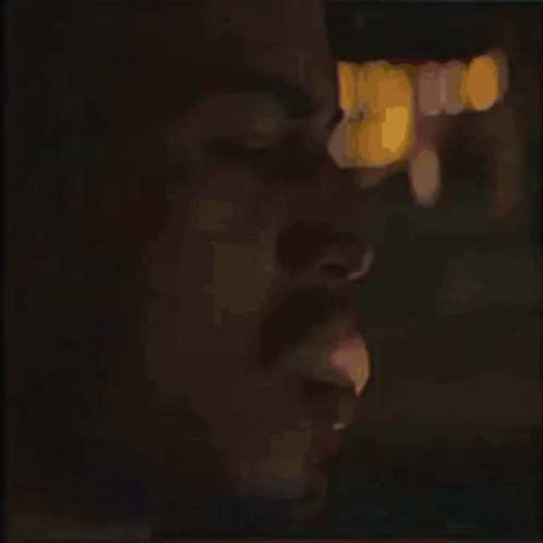 man making facial expression and posing for the camera at night