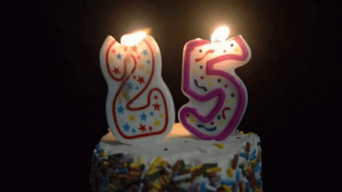 a birthday cake with lit candles that spell the number twenty five