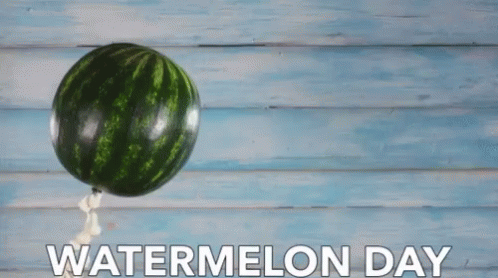 a watermelon is hanging on a wooden wall and the words watermelon day above it