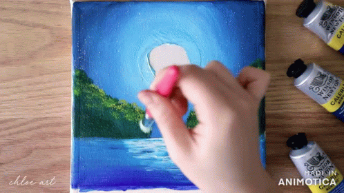 painting on canvas with a hand holding a paintbrush