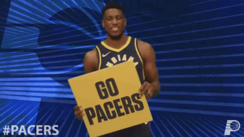 a man is holding a blue sign saying go pacers