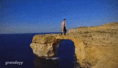 a man is walking over a gap in the water