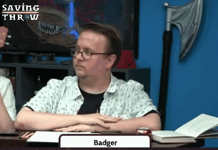 a man in glasses has his hand up to an adult who is reading the word badger