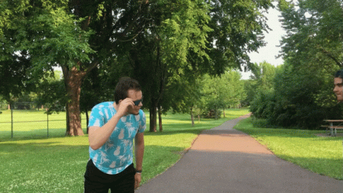 a man standing outside with a cell phone to his face