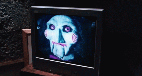 an old television showing a scary face with pink eyes