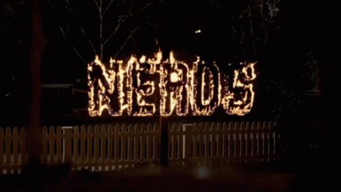 a sign is lit up against a fence