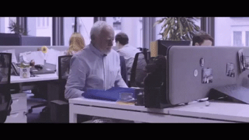 people working in an office building with cubicles and computers