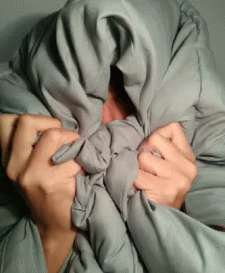 man covering his face with cloth with blue hands
