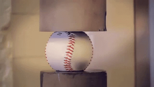 a baseball lamp sitting on top of a cement pillar