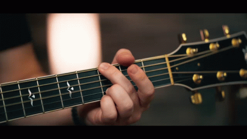 a close - up of a person holding an acoustic guitar in their hand