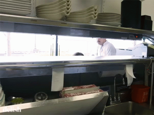 a restaurant kitchen with two chefs in the middle