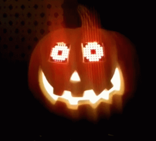 a carved pumpkin with eyes and glowing light in the dark
