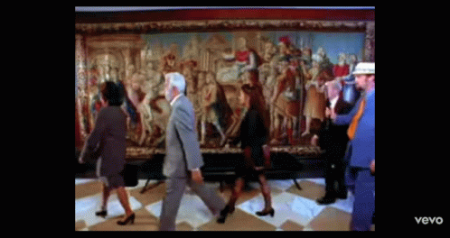 people are walking near a painting while the other man walks