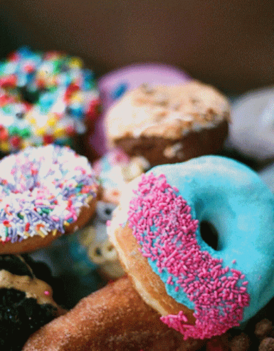 several donuts in different shapes and flavors, all colorfully decorated