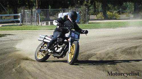 a man is riding a motorcycle down a dirt road