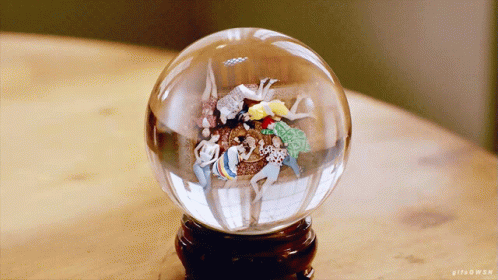 a snow globe with ornaments inside on a table