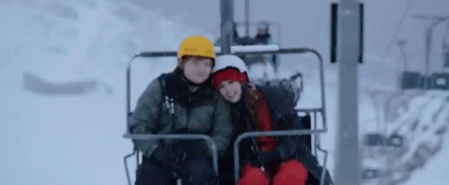 two people riding a ski lift and having fun