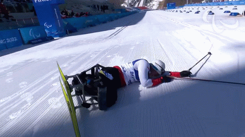 the snow skier is laying down in his skis