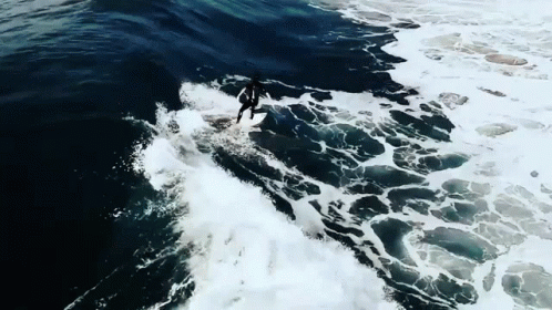 an aerial view of a surfer riding a wave