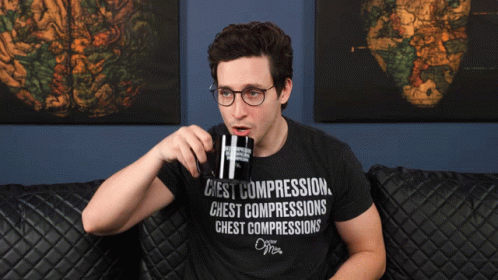 a young man with glasses uses a wine glass to drink