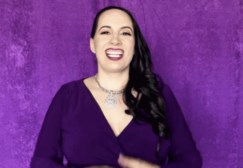 a woman poses for a portrait in a purple room
