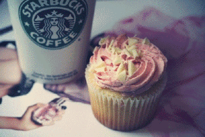 a blue cupcake and starbucks coffee on a table