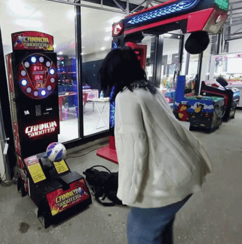 a man plays arcade games in front of a window