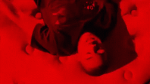 the man is asleep on his stomach in the blue light