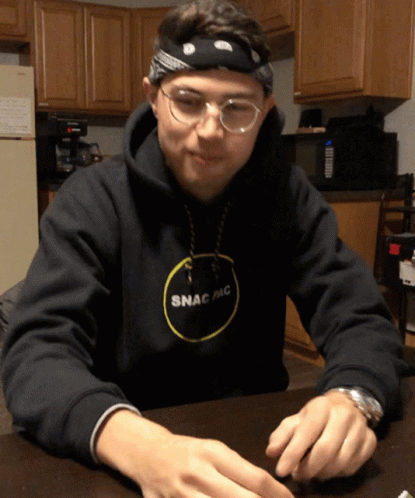 a man in a black hoodie playing with some dice