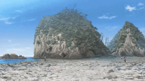 a beach has large rocks and trees in the background