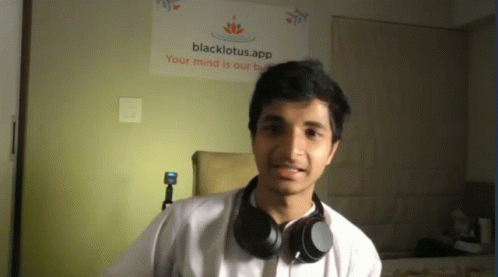 a man with headphones around his neck looks at the camera