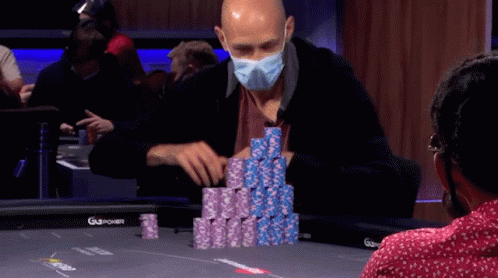 a man in a blue mask playing cards