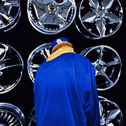 a person standing in front of some very large rims