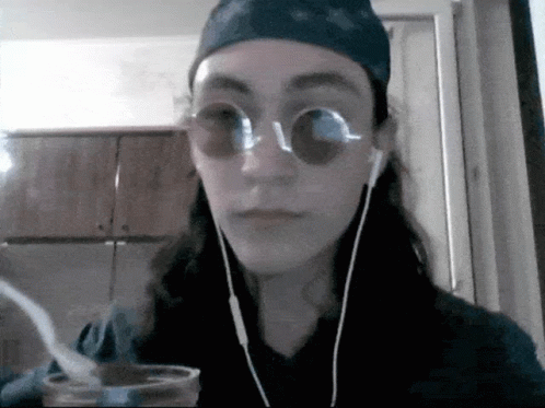 a person wearing glasses drinking out of a cup