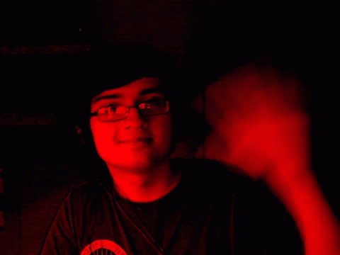 a young man with glasses at night with dark lighting