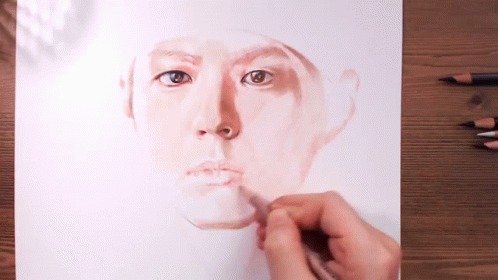the man is putting the color on the face of his drawing
