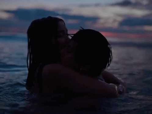 a couple sharing a kiss while floating in the ocean