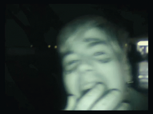 a man is licking his teeth in the dark