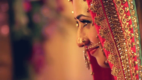 bride in her wedding makeup, she has a blue sari