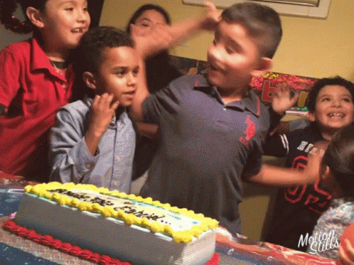 children around a birthday cake at a party