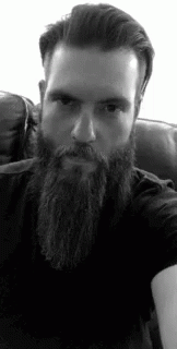 a man with a beard is sitting on a couch