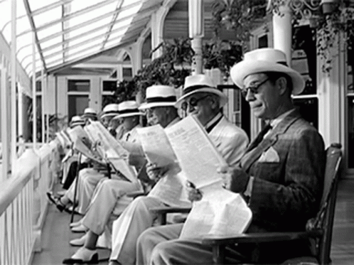 people sitting in chairs wearing hats and reading