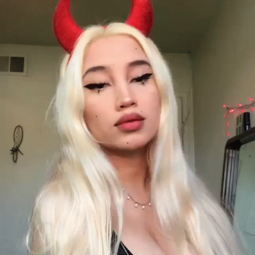a woman with long white hair and horns is taking a selfie