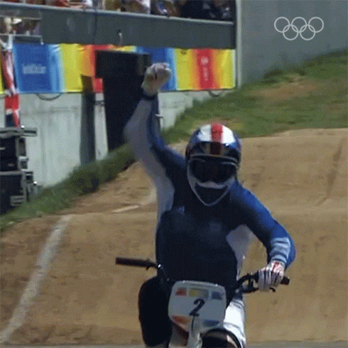 the olympic downhill racer is holding his hand in the air
