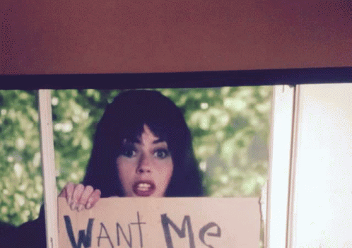 a woman holding up a sign in front of her face