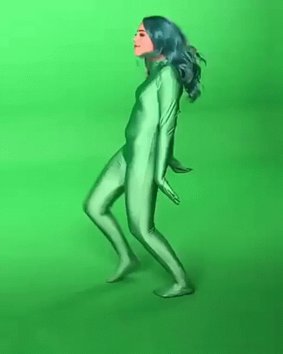 a woman with a mask is in front of a green screen