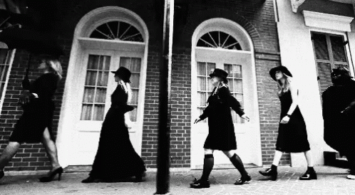 a line of women dressed in short dresses walking next to each other
