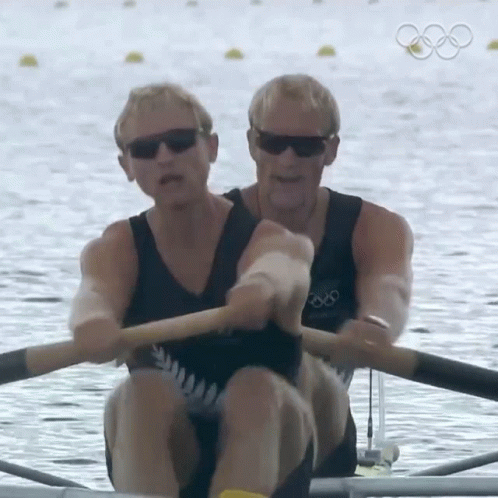 two male rowers are rowing on the water