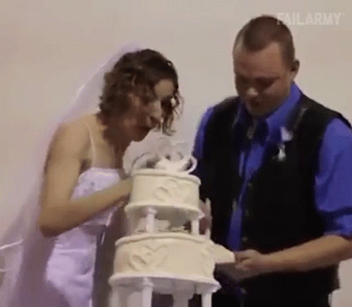 a man and a woman standing behind a cake